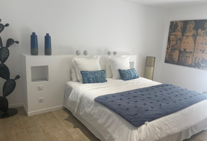 White bed with blue and white pillows in a cozy bedroom.