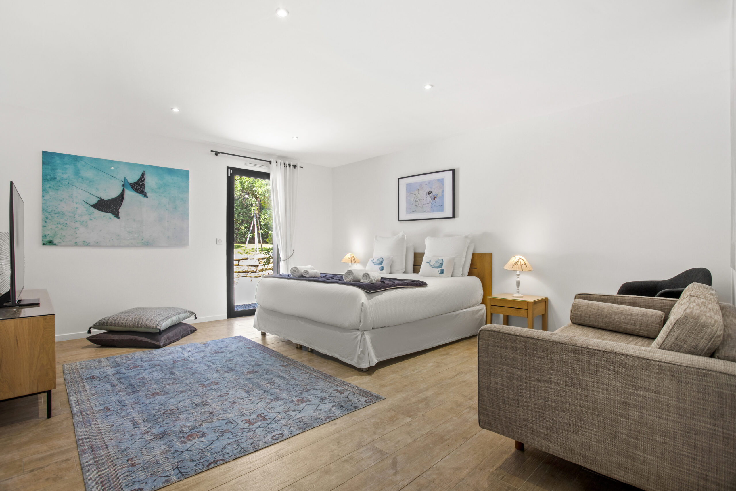 The Sailing Suite bedroom with king-size bed, lounge chair and private garden access
