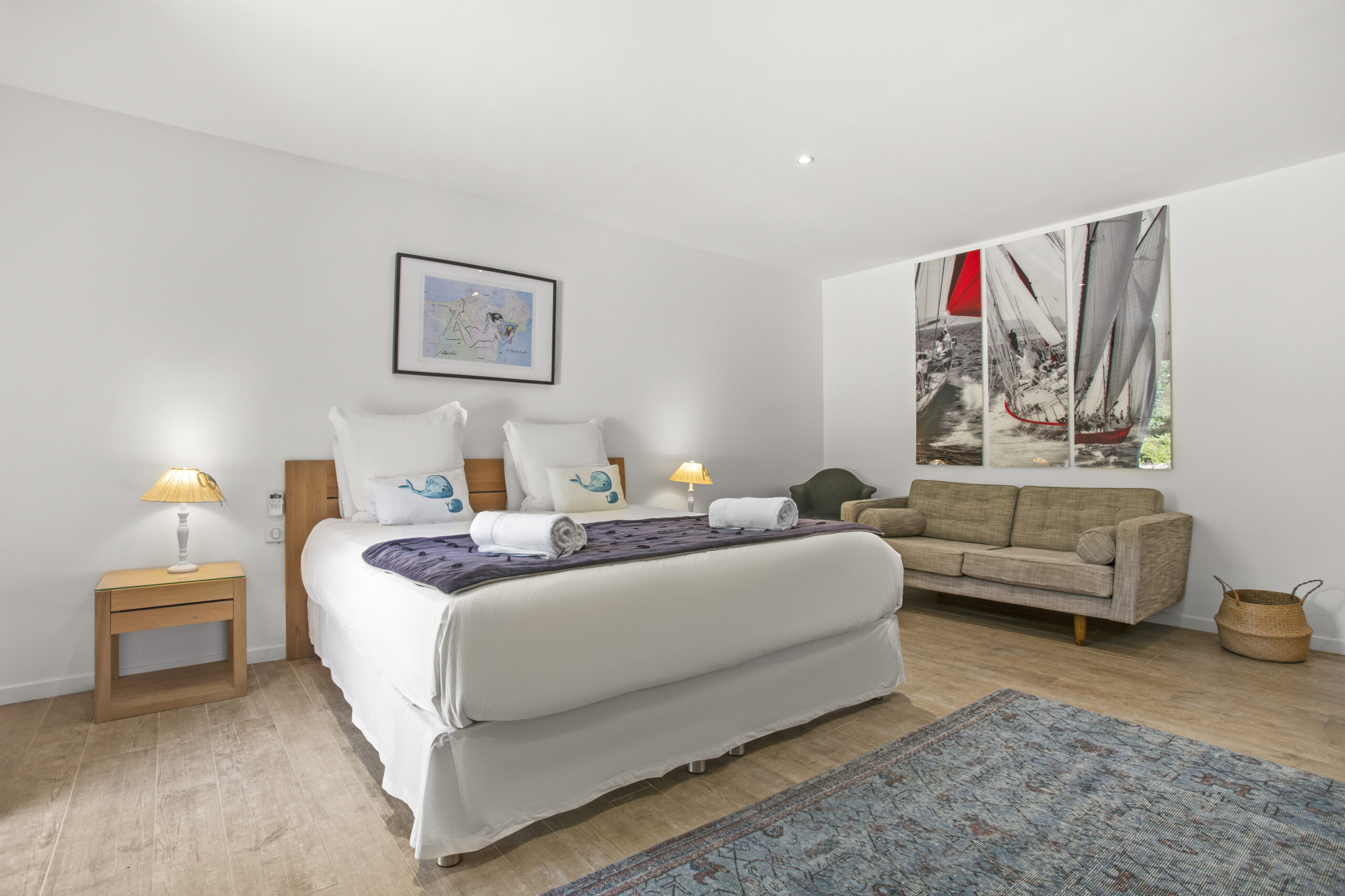 The Sailing Suite bedroom with sailing-inspired wall art and comfortable sofa
