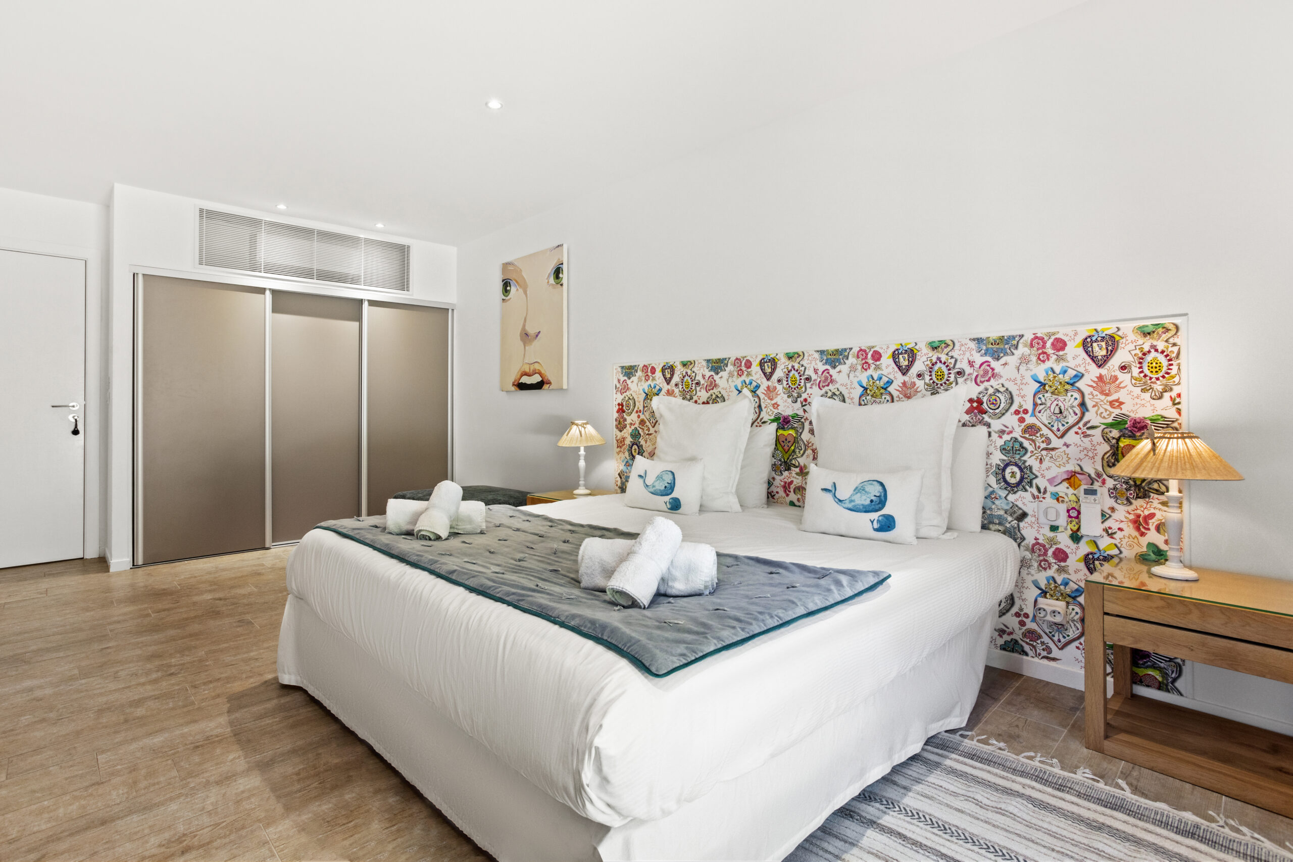 Detail of the coral suite at Villa Cycas showcasing a colorful artistic headboard and soft lighting