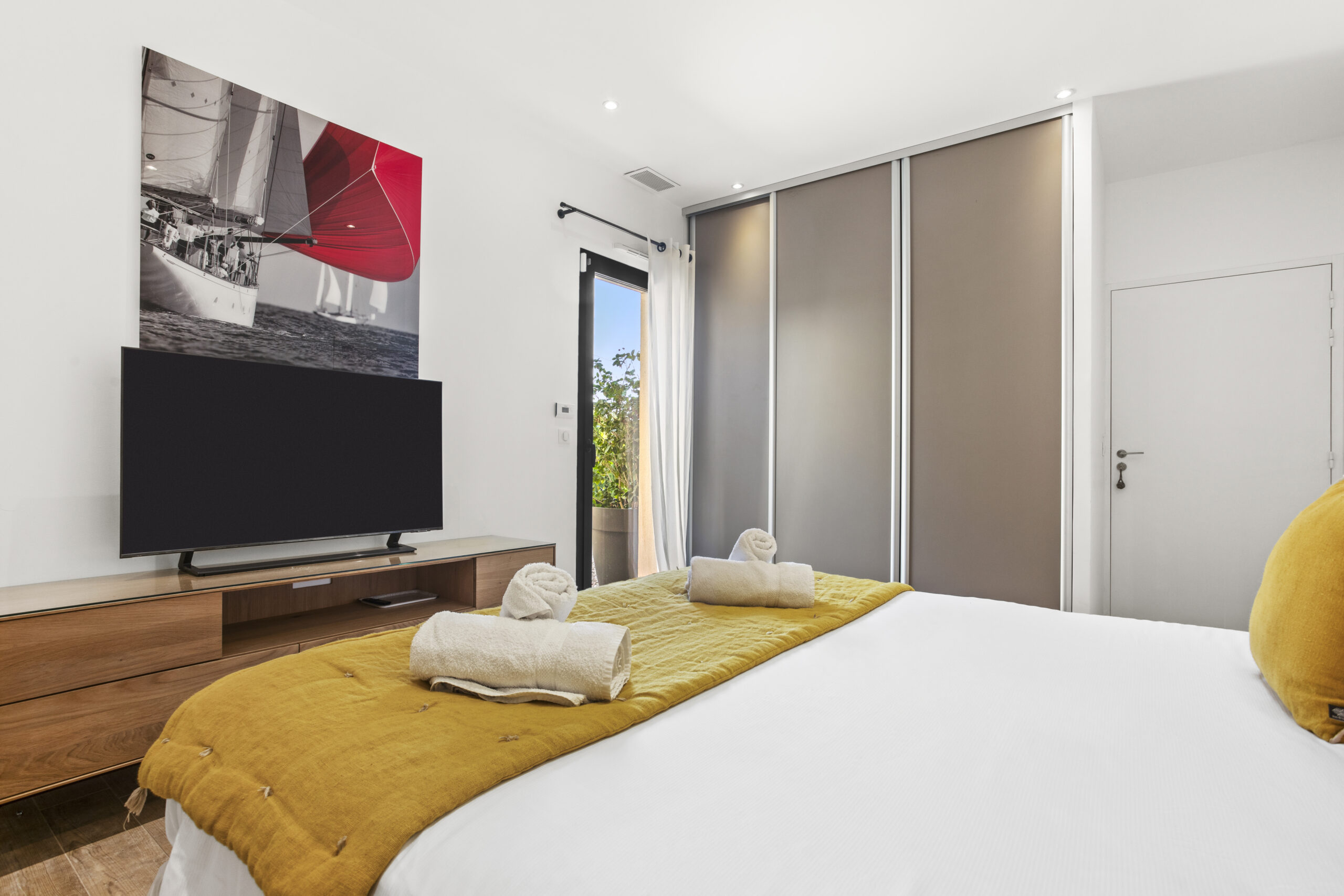 The Yellow Suite bedroom with king-size bed, TV area and nautical artwork